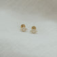 14ct recycled gold diamond evil eye studs on a beige linen background